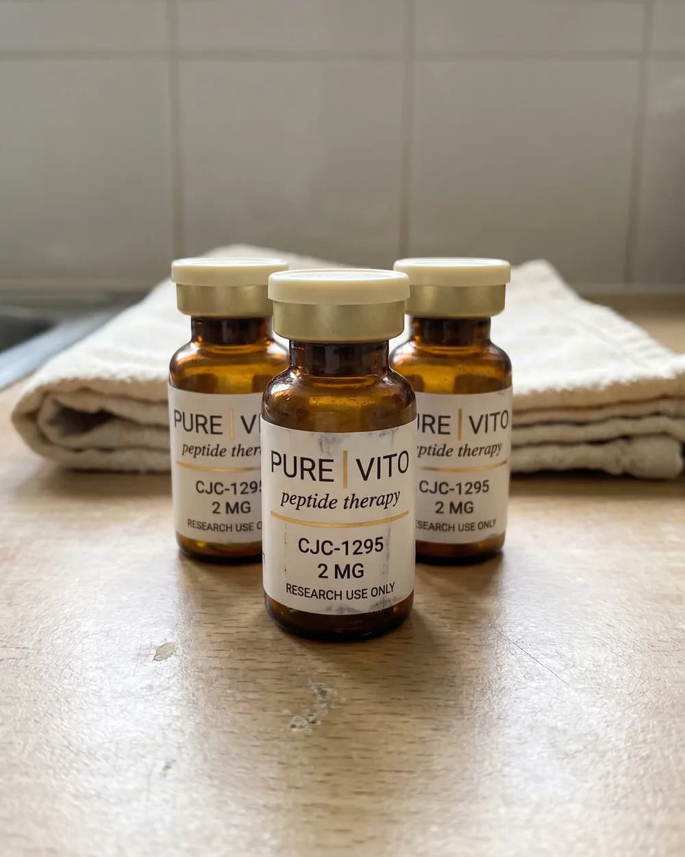 Three vials in a slightly untidy row on a kitchen worktop, with a folded tea towel behind them.